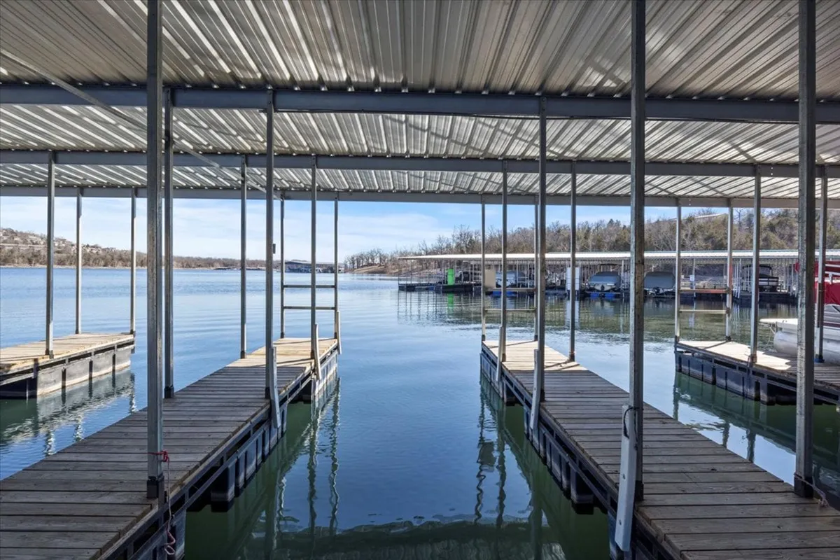 A broad view of a marina area, with extensive docks, calm reflective water, and boating facilities visible. The environment is peaceful, emphasizing ease of launching and maintaining boats.