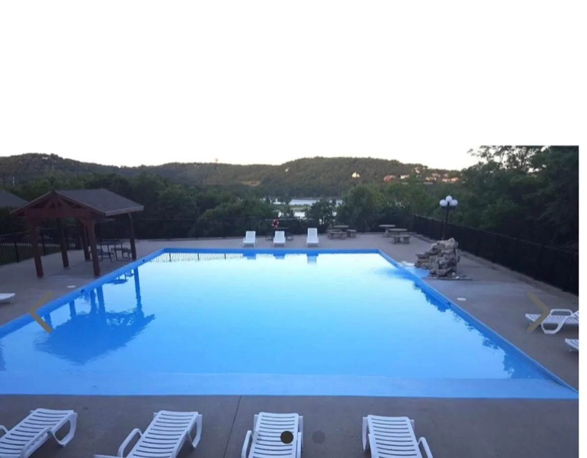 This exterior shot showcases a large swimming pool set against a stunning mountain view. Lounge chairs, a gazebo, and picnic tables surround the pool, hinting at opportunities for relaxation, socializing, and group activities. The scene feels tranquil yet welcoming for gatherings.
