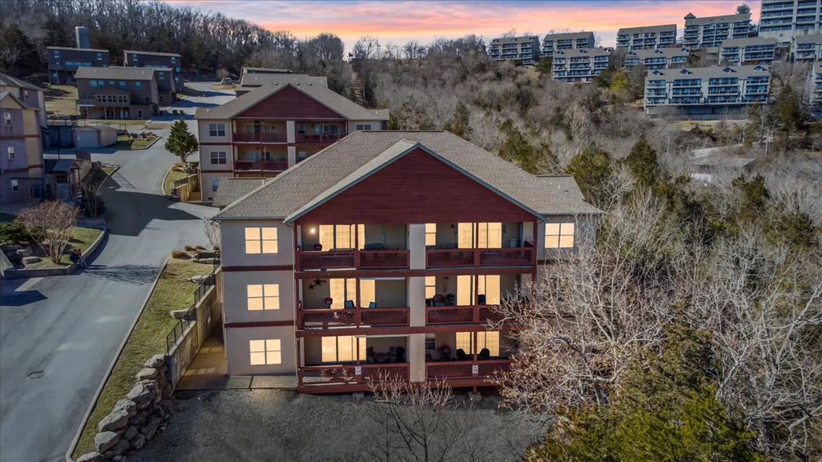 This exterior image highlights the building structure with balconies furnished for relaxation, framed by lush trees. The scene evokes a sense of social and leisure activities in the fresh air, with space for gatherings and unwinding outdoors.